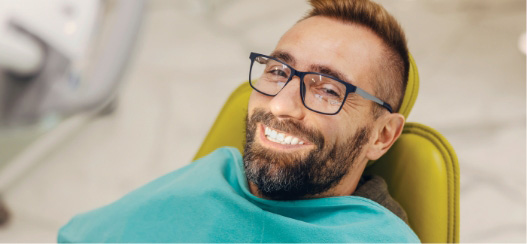 male dental patient smiling during dental exam