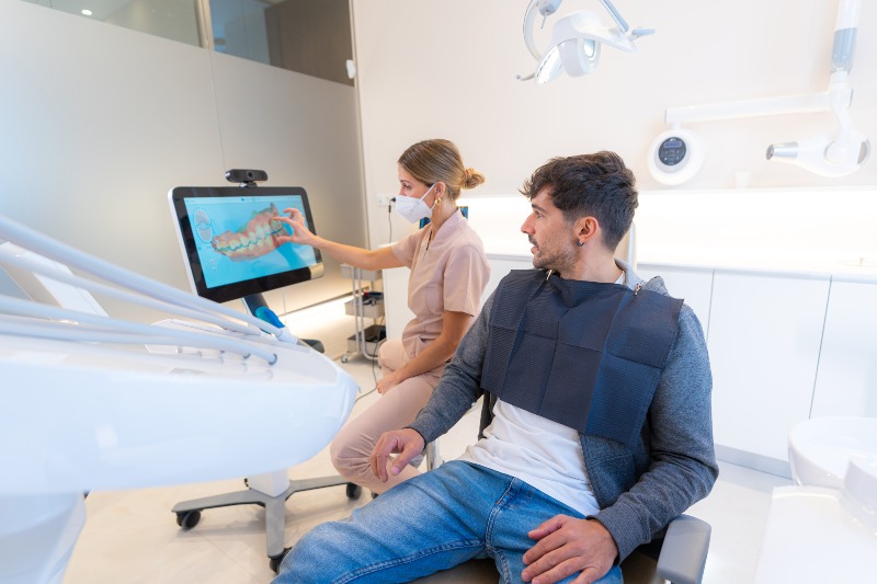 Dentist and patient reviewing a dental image on a screen