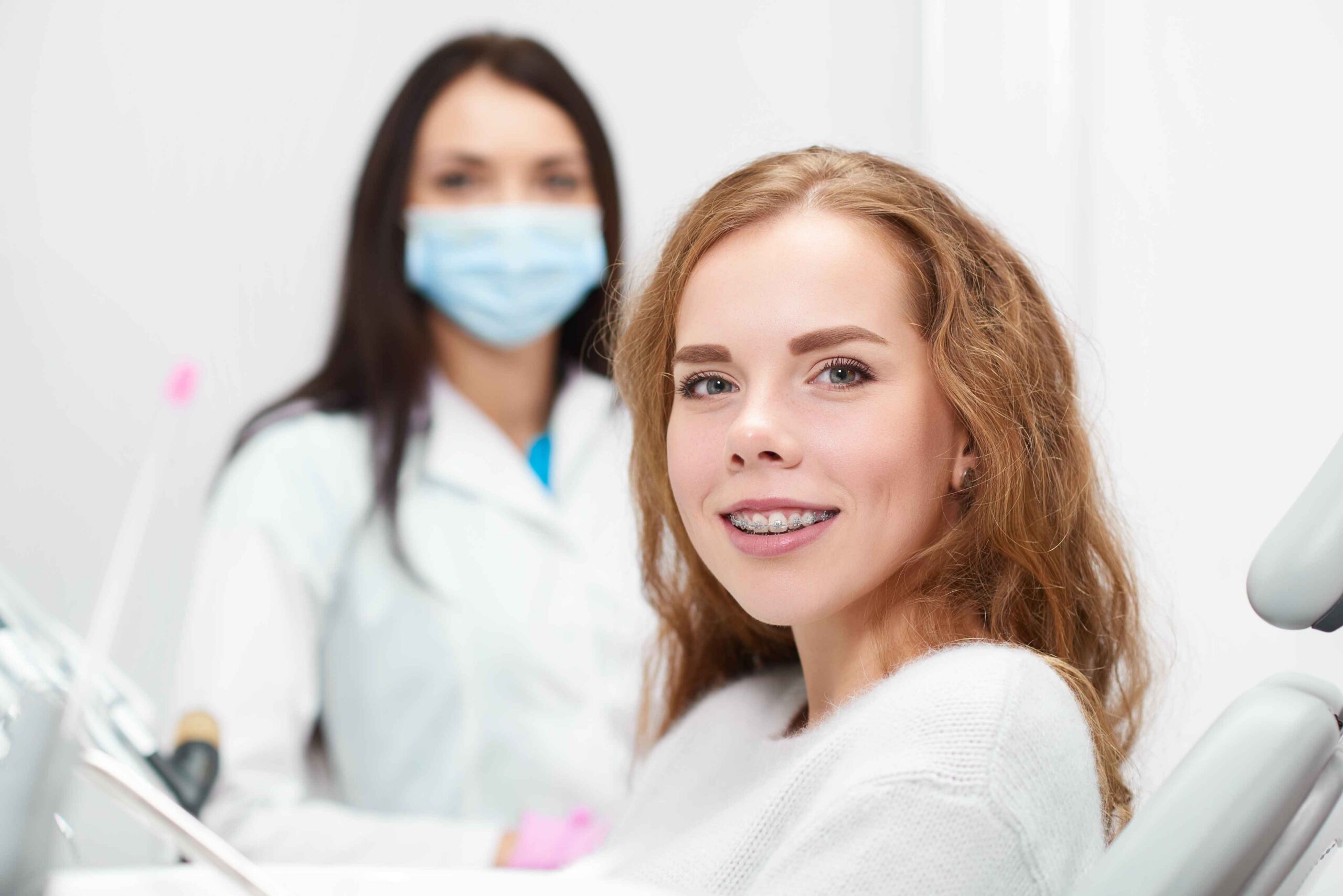 Smiling patient with braces at a dental visit.