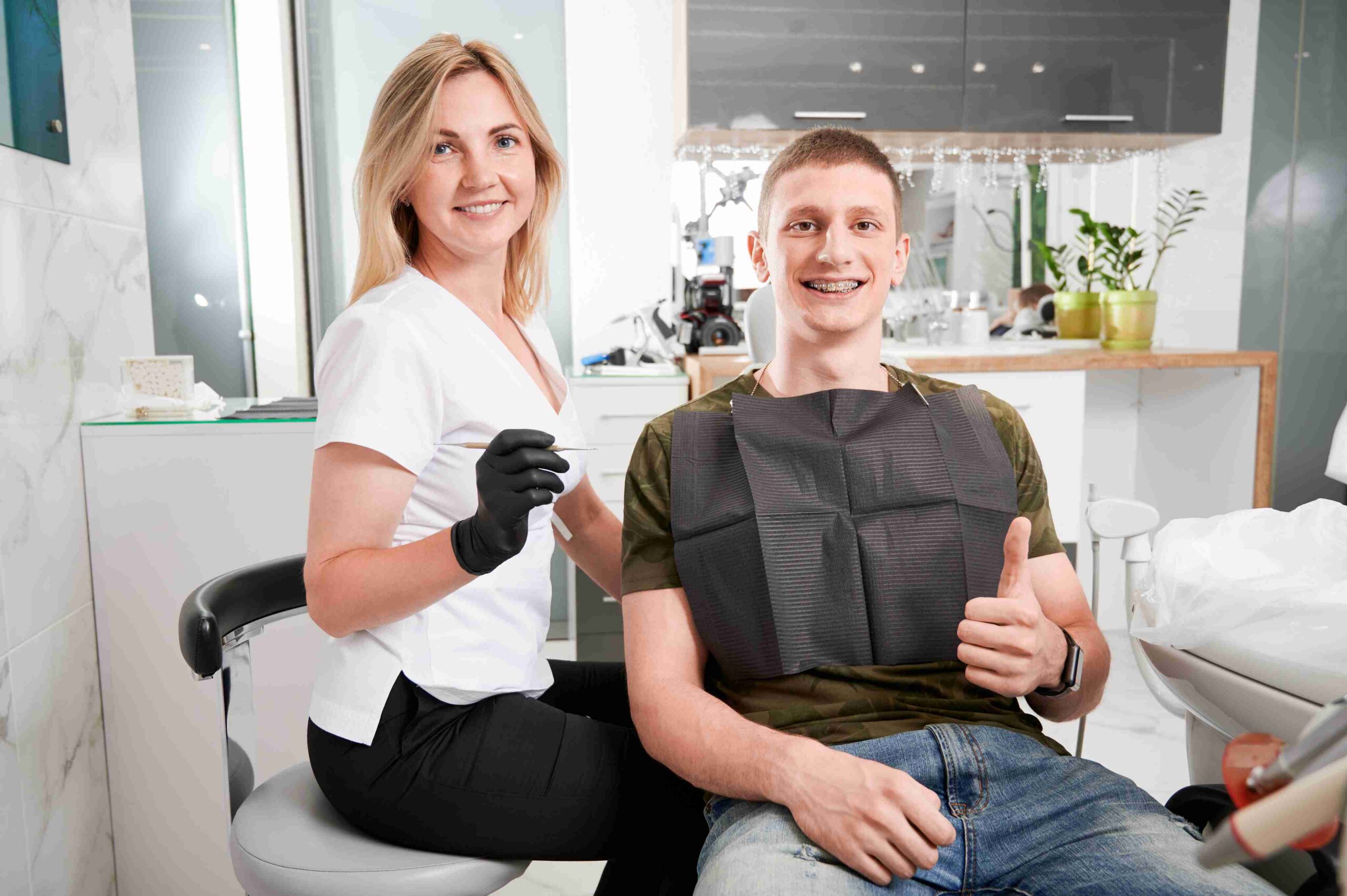 Dentist and patient smiling after treatment.