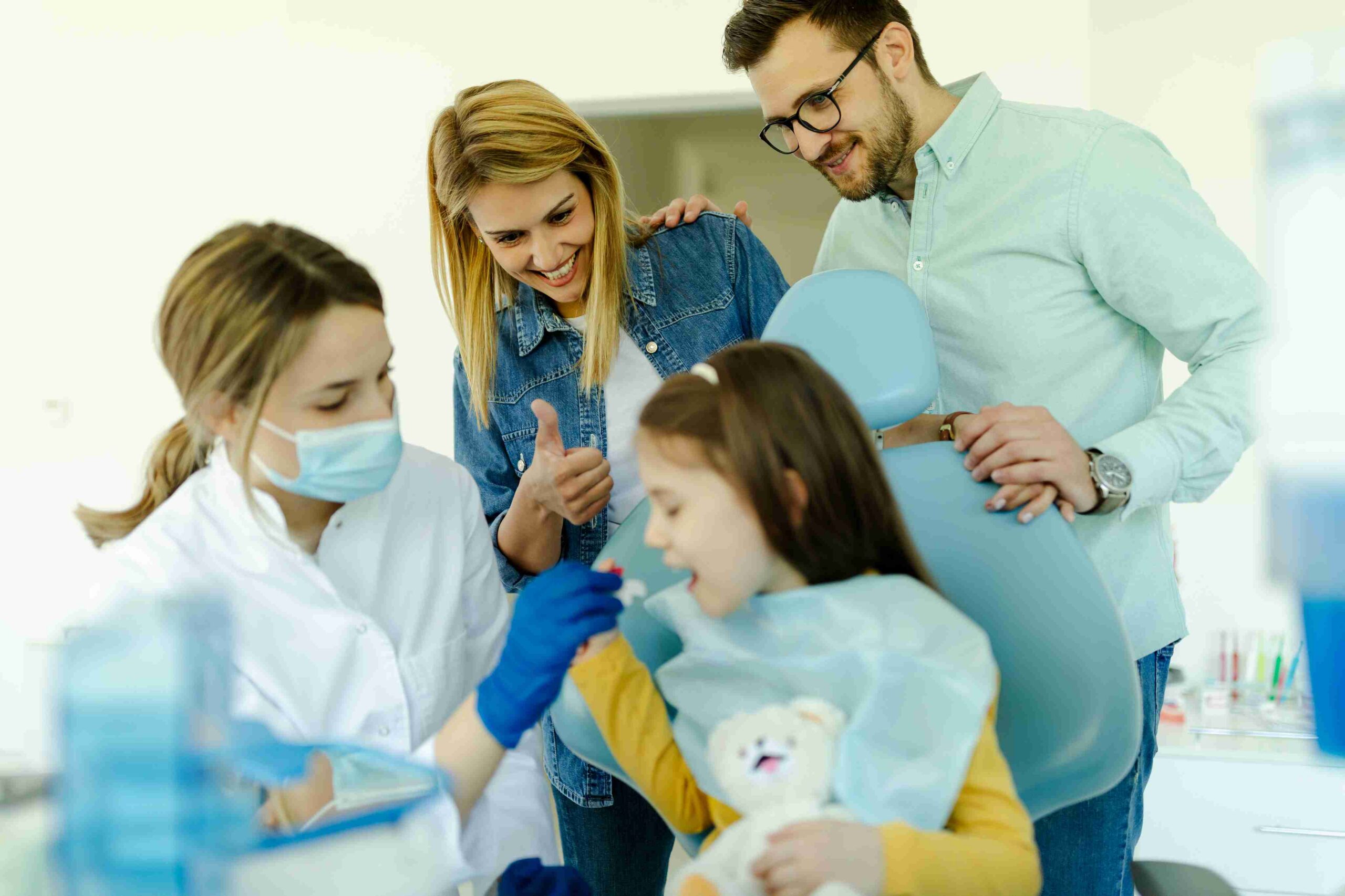 Child smiling during family dental visit.